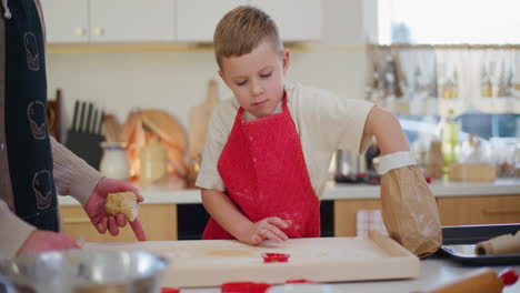 boy pours flour onto a board for kneading dough