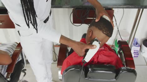 african man cutting african boy hair