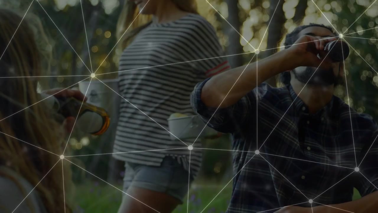 Uomo seduto che beve dopo aver ricevuto una bottiglia per socializzare nel bosco, con una sovrapposizione web che collega le persone per la tecnologia.