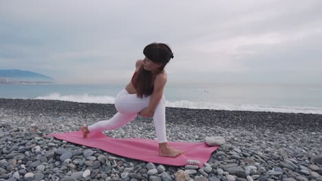 woman practicing yoga on a beach