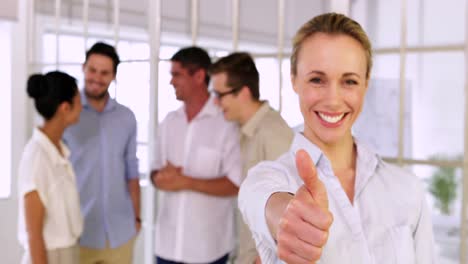 attractive blonde businesswoman showing thumbs up to camera