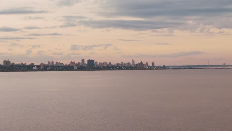 a stunning view of downtown posadas from the river during sunset, showcasing the city's beauty against the colorful evening sky