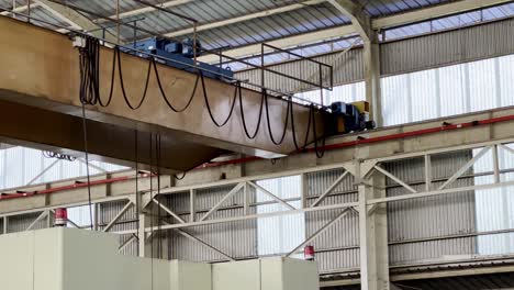 Close-up-shot-moving-overhead-crane-on-roof-of-factory-building