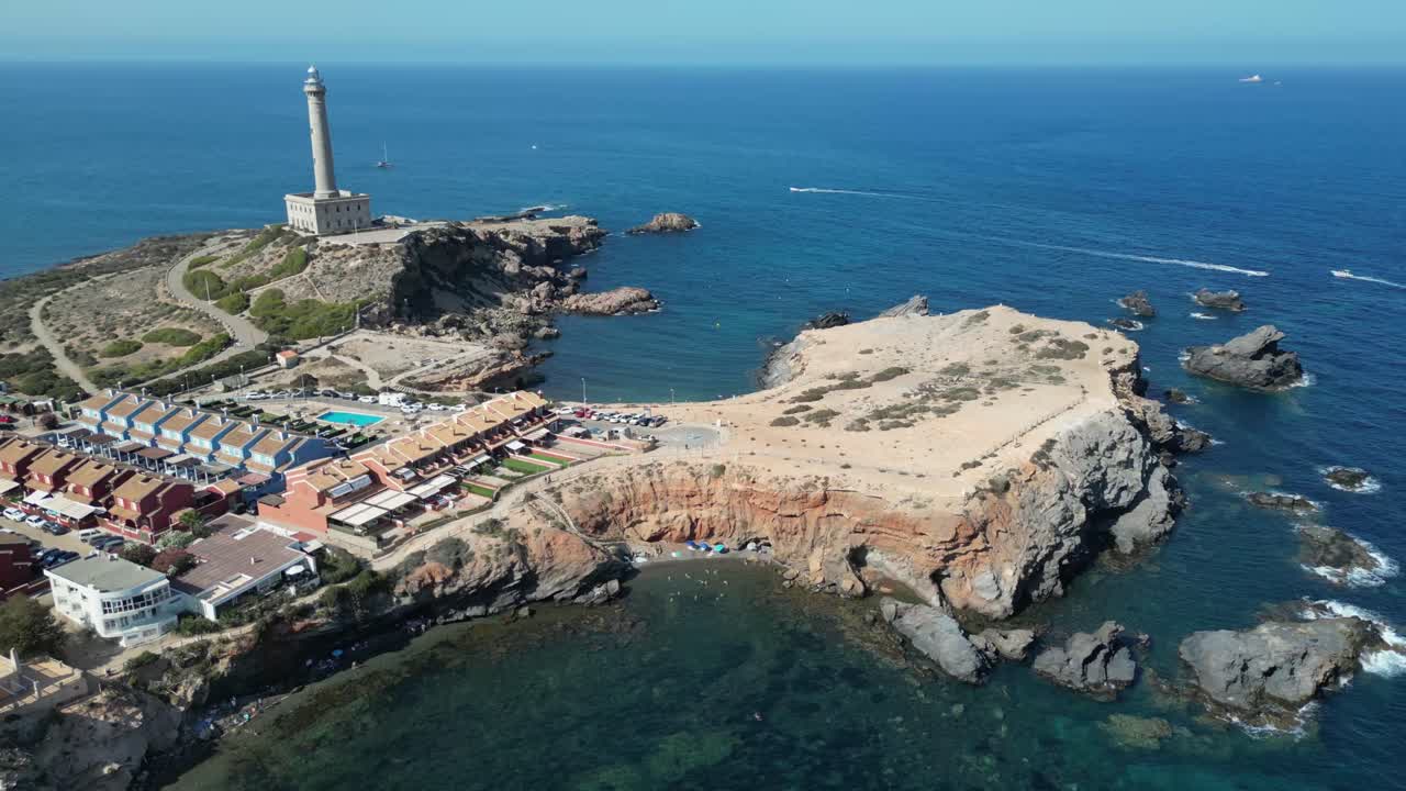 A captivating aerial drone descent reveals a vibrant cityscape featuring a lighthouse, a speeding boat, and the stunning blue waters of the Mediterranean Sea.