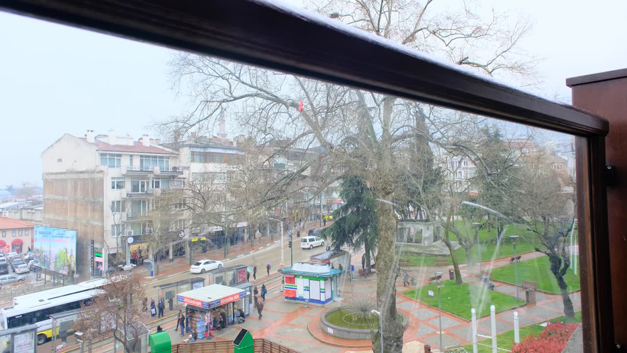 구름과 비가 오는 날에 부르사 시내. 사람들이 돌아다니고 교통.