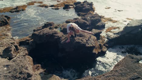 young woman on windy beach – serene scene of a girl discovering tidal rocks along a scenic japanese shore.