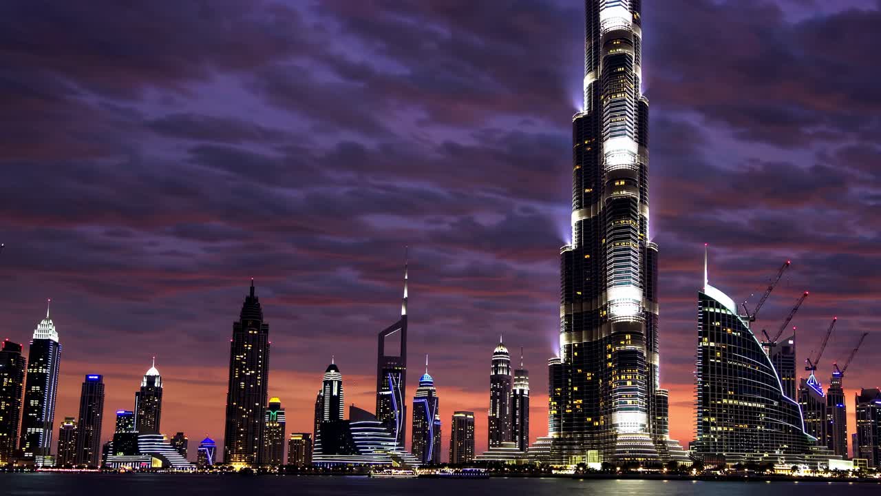 Un video grandangolare cattura uno skyline futuristico di città al tramonto, con imponenti grattacieli.