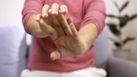 detalle de manos femeninas estirándose después de un intenso día de oficina en casa