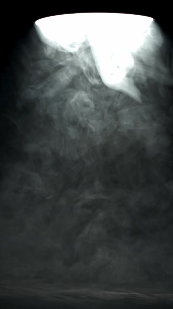 Faro luminoso che illumina fumo vorticoso su sfondo scuro