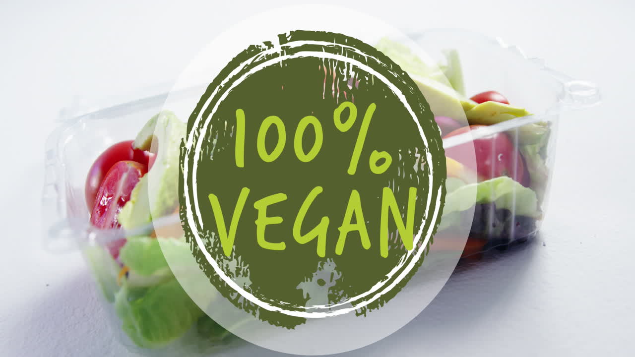 Vídeo de texto '100% vegano' sobre caixa com vegetais frescos.