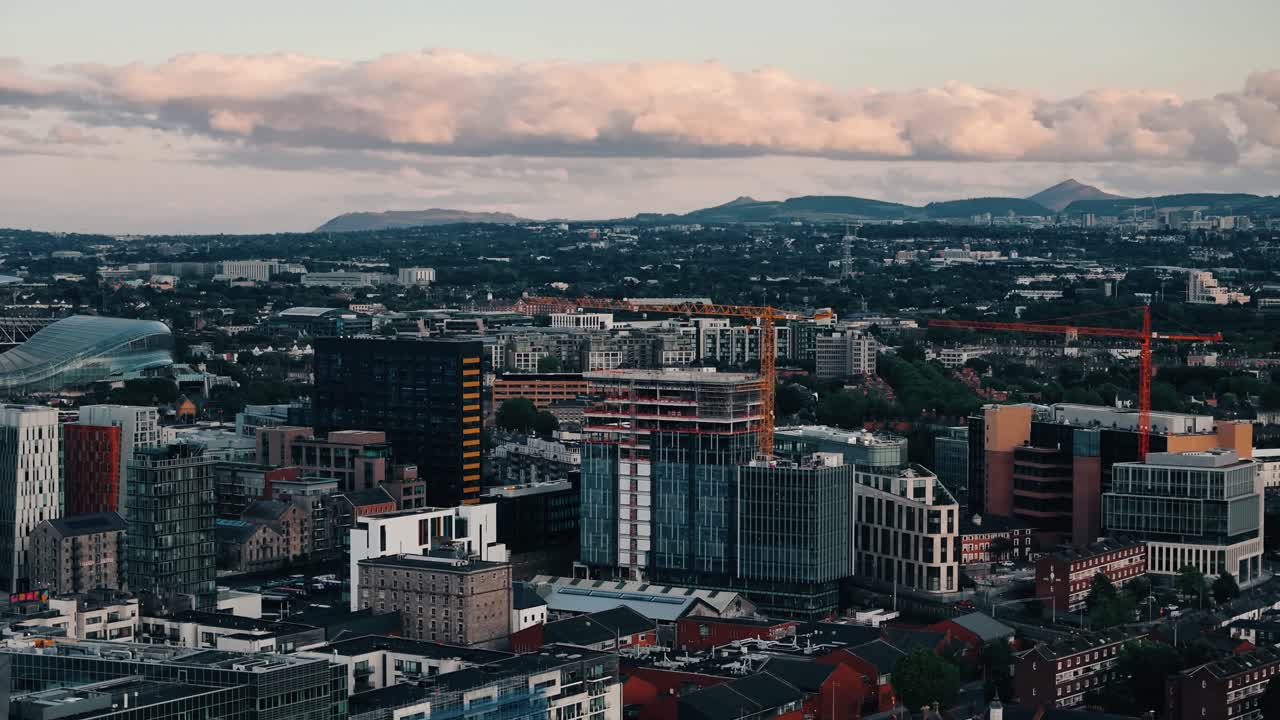 Quick ascending aerial establishing view of Dublin at vivid sunset