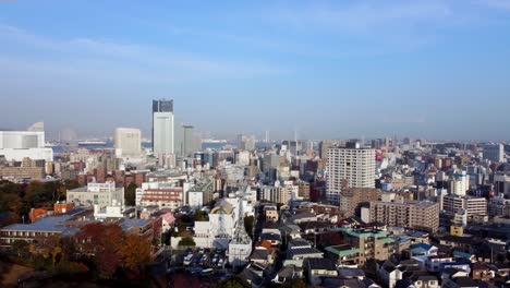 autumnal hues blanket a bustling cityscape under a clear blue sky, wide aerial shot