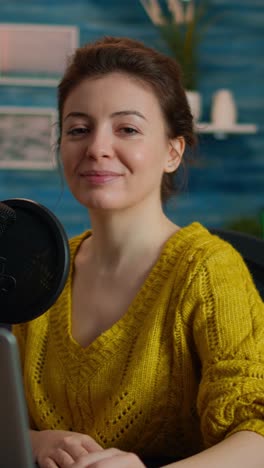 vertical video: social media influencer smiling at camera sitting in home studio