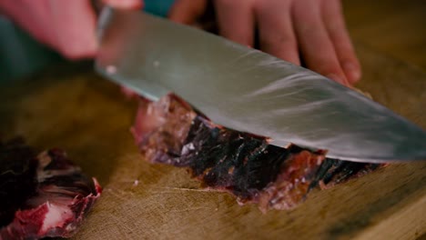 sacando la capa superior extra del bistec con un cuchillo pequeño en una vista de primer plano
