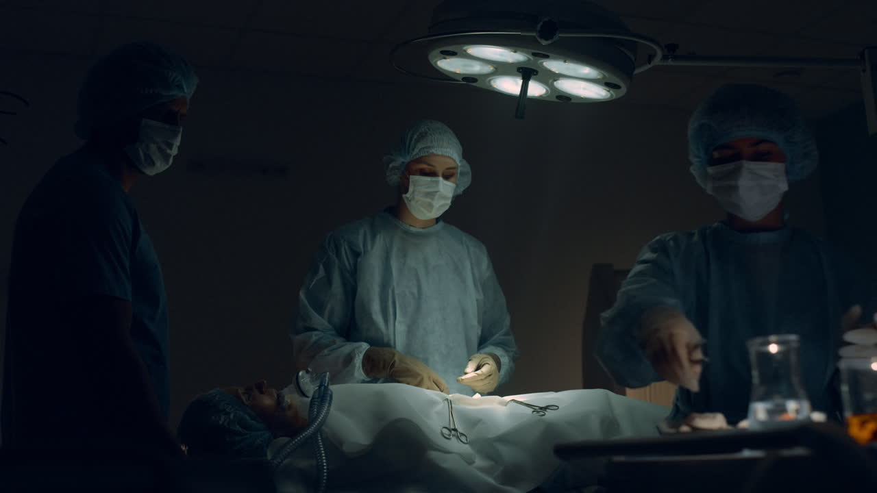 equipo médico realizando una cirugía en la habitación del hospital. cirujano pasando instrumentos.