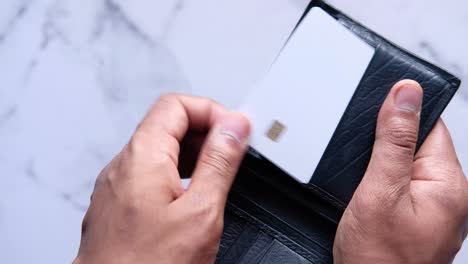 persoon die een portemonnee opent met een creditcard