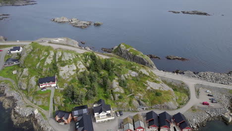 La-Panorámica-Aérea-Revela-Una-Toma-De-Un-Pintoresco-Pueblo-En-La-Isla-Rocosa-De-La-Costa-Con-Acantilados-Y-Montañas-Al-Fondo-En-Un-Día-Nublado