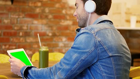 hombre escuchando música en una tableta digital