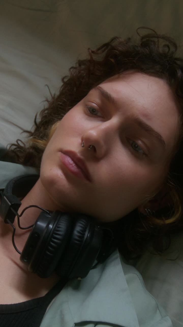 mujer con auriculares acostada en la cama