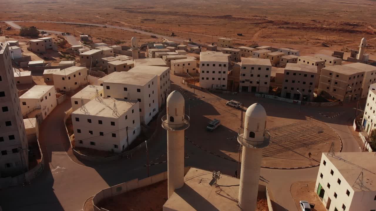 aerial shot of two mosques next to the main squere in an old empty city in the desert in palestine near Gaza at sunset.