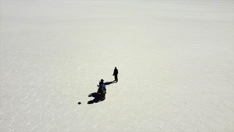 aerial orbits moto and rider on hexagonal pattern salt flat in bolivia