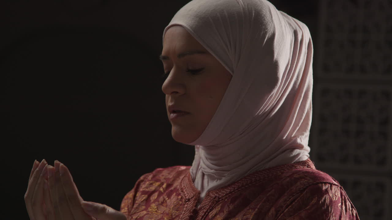 머리와 어깨: 히자브를 입고 기도하는 무슬림 여성의 초상화