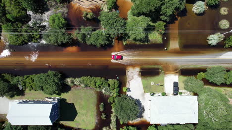 downward angle drone shot of car driving through flooded roads