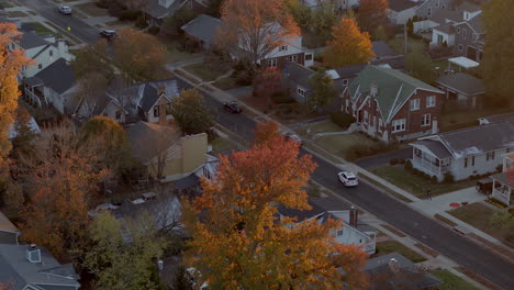 Aerial-over-suburban-neighborhood-in-Autumn-as-a-car-pulls-into-a-driveway