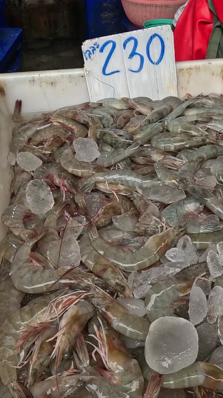 руки сортируют креветок и рыбу на рынке морепродуктов