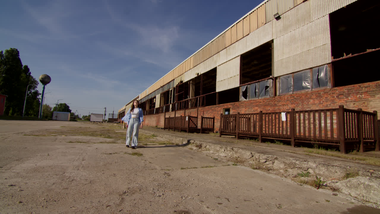 Woman walking in front of an abandoned factory