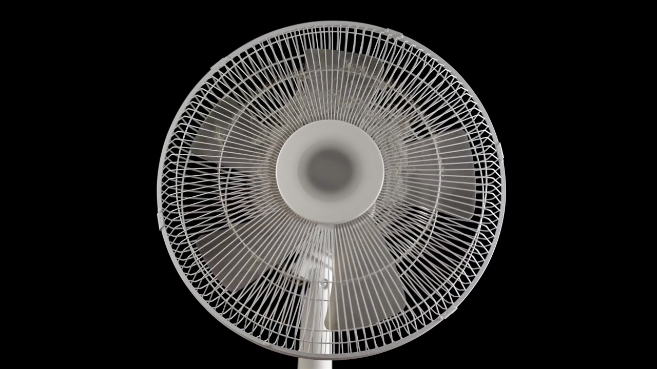 Hvid oscillerende ventilator drejer mod en ensfarvet sort baggrund i nærbillede.