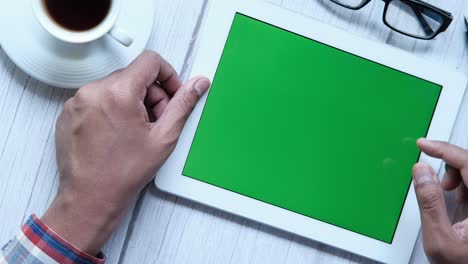 persona que utiliza una tableta con una pantalla verde