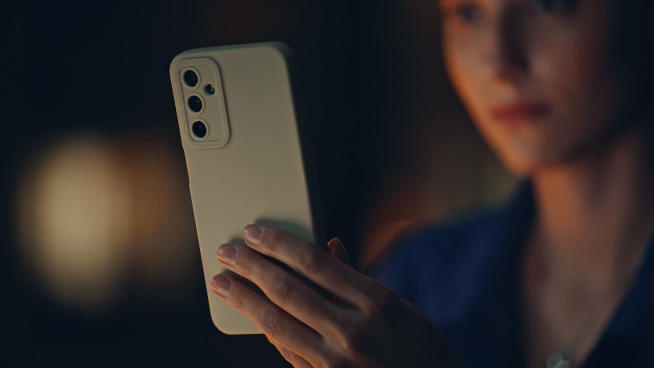 Overtime manager looking cellphone at night office closeup. Woman hand holding