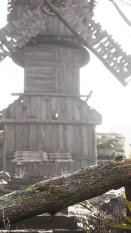 old wooden windmill in a foggy field