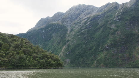 los imponentes acantilados verdes de milford sound se elevan sobre aguas tranquilas