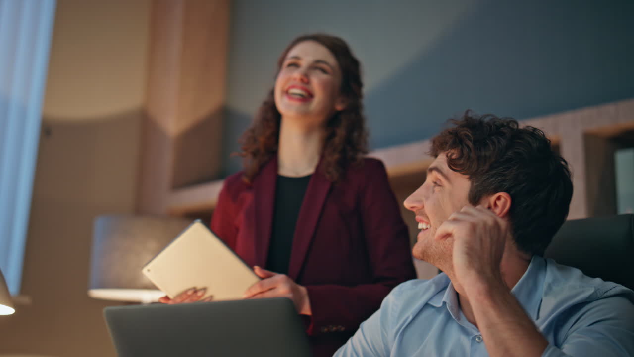 Two business people laughing together at office close up. Smiling businessman