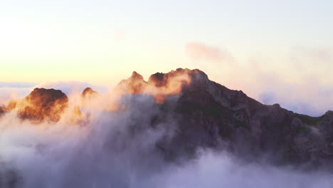 mountain peak shrouded in clouds during the magic hour