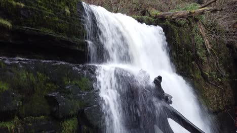 A-close-up-drone-shot-of-a-waterfall,-climbing-from-the-base-of-the-falls-up-to-the-top