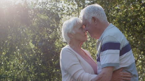 Happy-senior-caucasian-couple-embracing-in-sunny-garden,-slow-motion,-copy-space