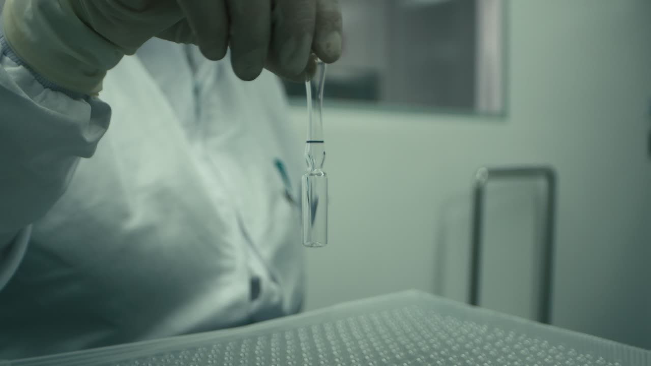 Closeup shot of half filled ampule being hold by a medical practitioner