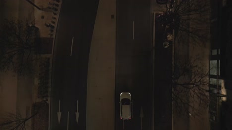 Paris streets at night, car driving through illuminated urban roads, France. Aerial top-down forward