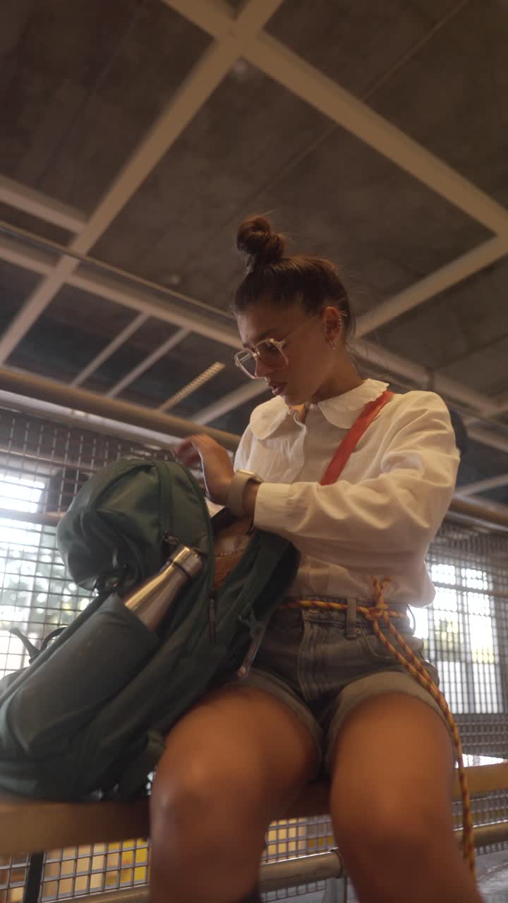 Woman Sitting on Bench, Inspecting Backpack