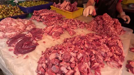 workers organizing various cuts of meat on table