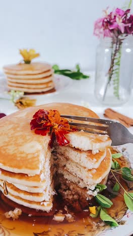 delicious stacked pancakes with maple syrup and flowers