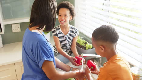 washing hands together, african american family bonding in kitchen near window
