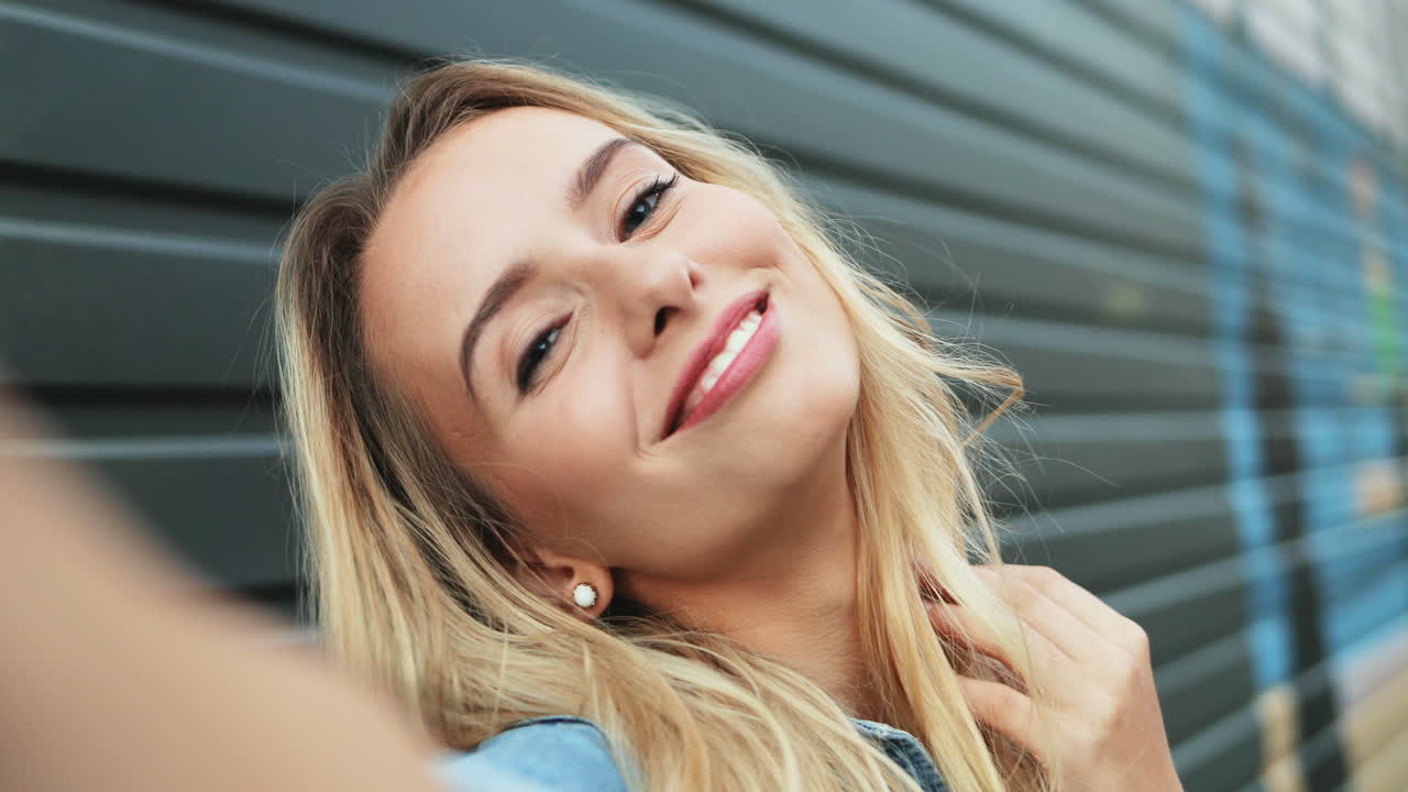 Close-up view of Caucasian young woman while taking a selfie in the street