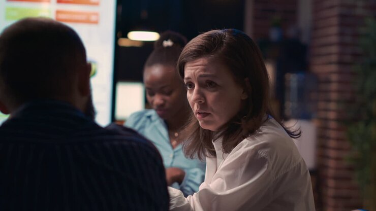 Donna che parla con un dipendente durante una riunione di lavoro