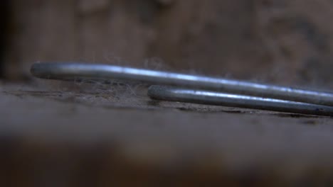 an extreme close up panning shot of a paperclip that sits on a ledge