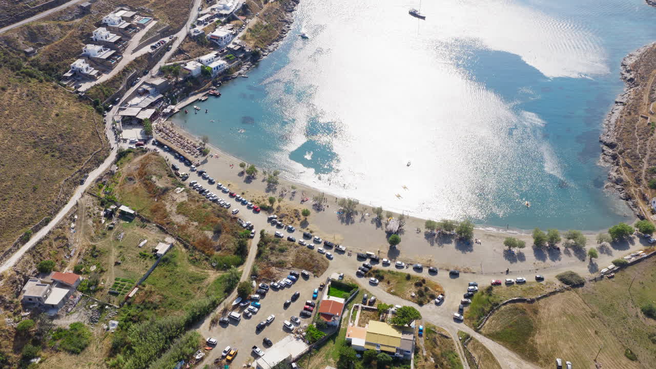 Slow orbit drone shot over Episkopi Beach in Kythnos island, Greece, showcasing turquoise waters, golden sand, and summer serenity