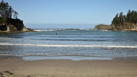 paddle boarder at sunset bay state park, oregon